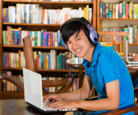 student working on laptop in library