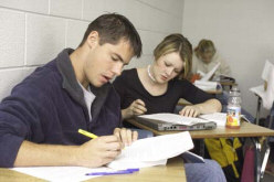 Students writing in notebooks for spelling and vocabulary.