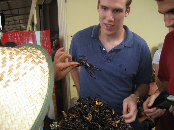 Tourists Indulging in a Local Cambodian Delicacy - Fried Spiders