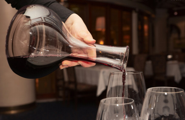 Waiter Pouring Red Wine From a Decanter
