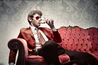 young man sitting on sofa sipping wine