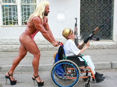 Muscle Man in Heels pushing Wheelchair with Machinegun Armed Man