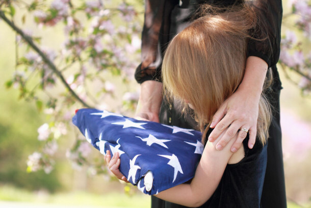 child holding a folded american flag